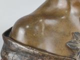 bronze statue of a woman with a flower on her shoulder