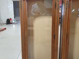 two tall wooden cabinets with glass doors in a room