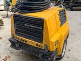 a yellow construction vehicle parked in a lot with other construction equipment
