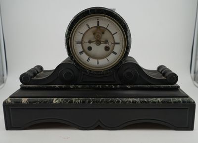 a black and white clock on a stand on a table