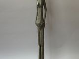 statue en bronze d'une femme debout sur un socle noir