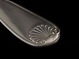 a silver spoon with a design on it on a black background