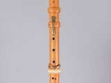 an image of a flute with a wooden body on a grey background
