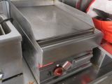 plan de travail en acier inoxydable dans une cuisine professionnelle équipée d'un four à plaque chauffante