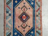 tapis posé au sol, orné d'un motif bleu et rose