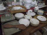 many plates and bowls on a table with a wooden spoon