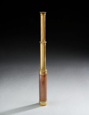 un télescope ancien en laiton et en bois posé sur une surface blanche