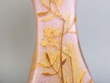 un vase rose orné d'un motif à la feuille d'or