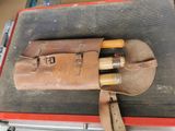 a leather tool bag with a pair of tools in it