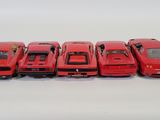 six red toy cars are lined up in a row on a white surface