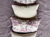 three pillows are stacked on top of each other on a bed