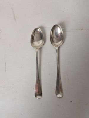 two spoons sitting next to each other on a table