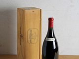 a bottle of wine sitting next to a wooden box on a table