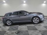 the grey audi is parked in the garage on a checkered floor