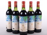 quatre bouteilles de vin sont alignées sur une surface blanche
