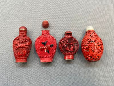 trois vases rouges sont alignés les uns à côté des autres sur une table