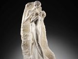 a white marble statue of an angel holding a child
