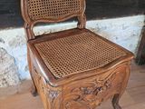 a wooden chair with a wicker seat on a wooden floor