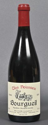 bottle of red wine sitting on a table with a gray background