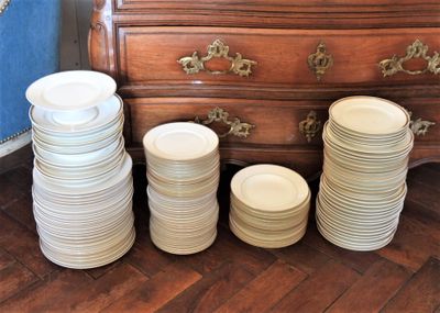 de nombreuses assiettes empilées sur une commode dans une pièce
