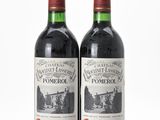 two bottles of wine sitting next to each other on a white surface
