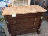 une commode en bois avec un plateau en marbre dans une chambre