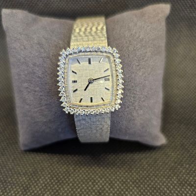 une photo d'une montre posée sur un oreiller, sur une table