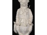 une statue blanche représentant un homme assis sur un oiseau