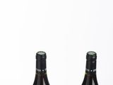 two bottles of wine sitting next to each other on a table