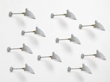 six white wall lights are arranged in a row on a white surface