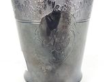 a silver vase with a design on it on a white surface