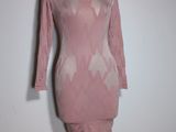 pink dress on a mannequin stand against a white wall