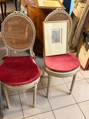une paire de chaises avec des coussins rouges et un cadre photo fixé à leur dossier