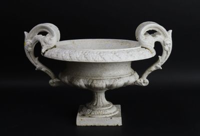 une urne blanche posée sur une surface noire