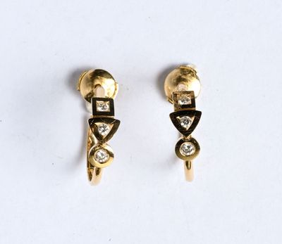 une paire de boucles d'oreilles en or et diamants posées sur un fond blanc