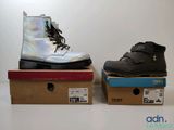 une paire de bottes noires et argentées posées sur des cartons