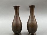 two brown vases sitting next to each other on a gray surface