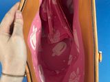 someone is holding a purse with a pink bag inside of it