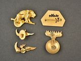 a lot of gold brooches and pins on a table