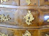 a wooden chest of drawers with gold decorations on it