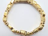 a close up of a gold bracelet on a white surface