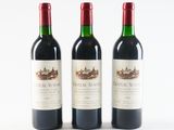 three bottles of red wine sitting next to each other on a white surface