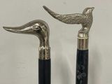 pair of black and silver walking canes with a bird handle