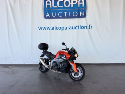une moto rouge garée devant un mur blanc