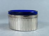an image of a silver and blue glass container sitting on a table