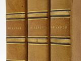 three books are lined up in a row on a white surface