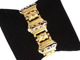 an image of a gold and blue bracelet on a black velvet napkin