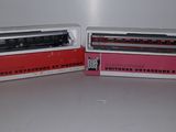 deux petits trains jouets posés côte à côte sur une table