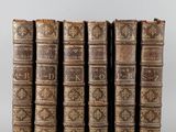 a set of five old books sitting on top of each other