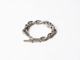 un gros plan d'un bracelet à maillons posé sur une surface blanche